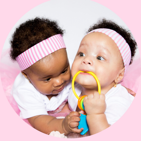 Twin baby girls playing with toy